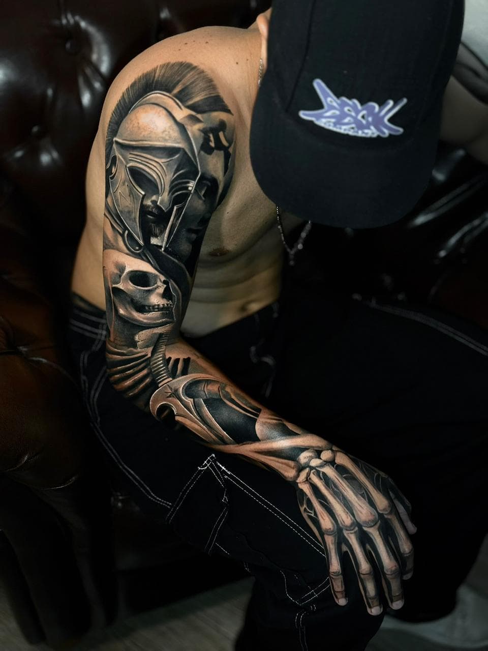 Fechamento de braco com elmo espartano, cranio e mao esqueletica em realismo