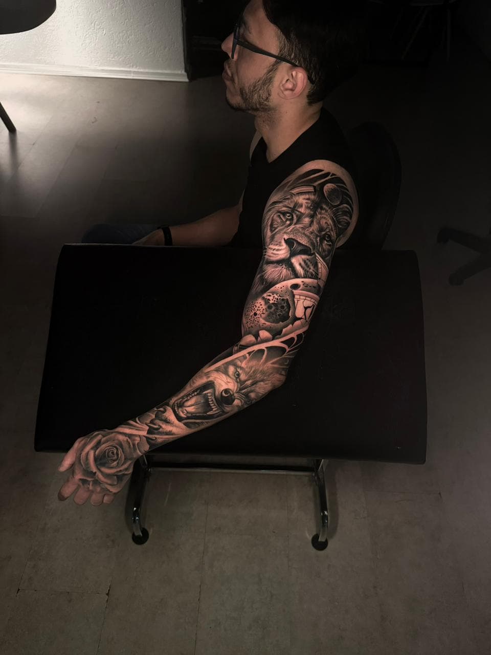 Fechamento de braco com leao, cranio de felino e rosa em preto e cinza
